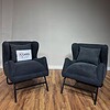 Accent chairs with metal base covered in dark grey boucle fabric.