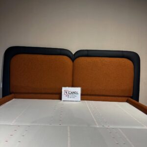 Bedframe with vibrant orange matte fabric with black leather top and strap