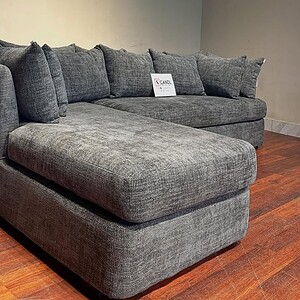 Dark grey 6-seater sectional sofa features plush backrests.
